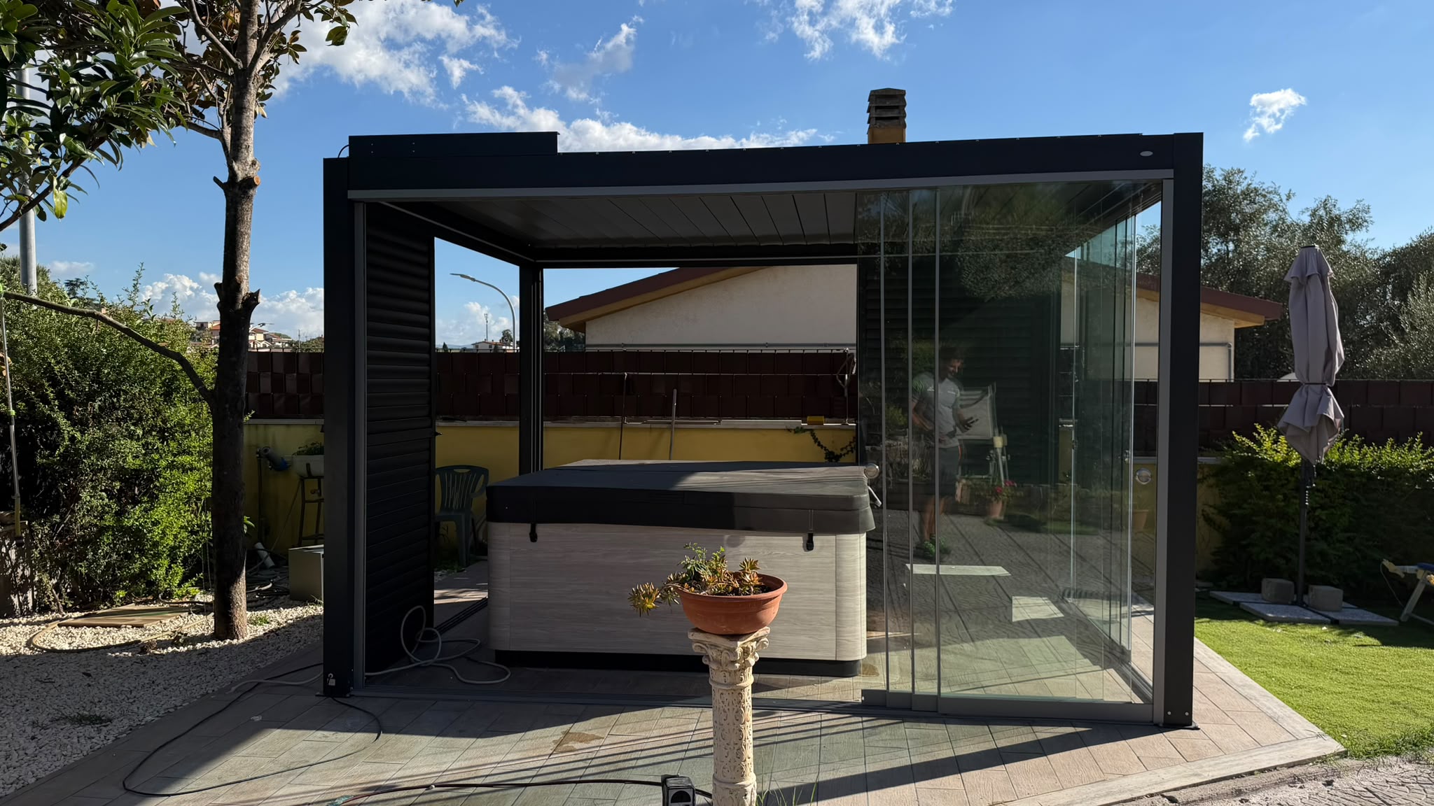 Pergola bioclimatica con vetrate scorrevoli panoramiche e vasca idromassaggio
